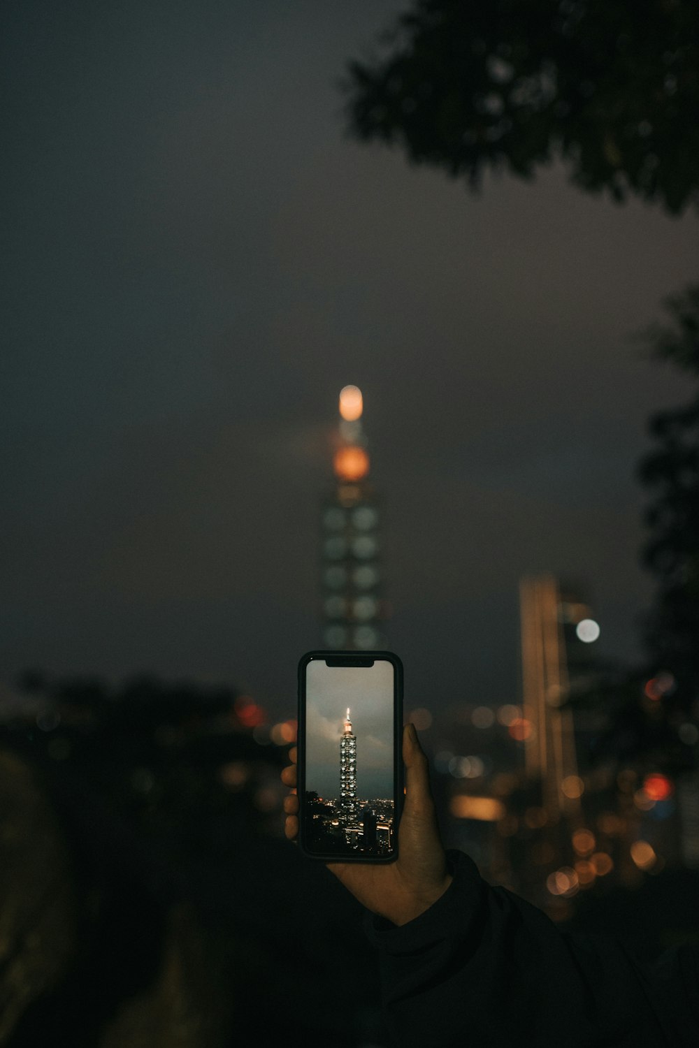 Person, die nachts Fotos von den Lichtern der Stadt macht