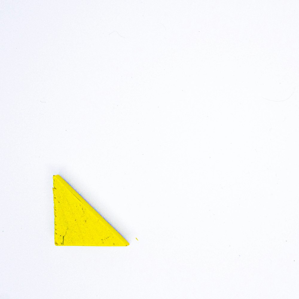 segno di freccia gialla su parete bianca