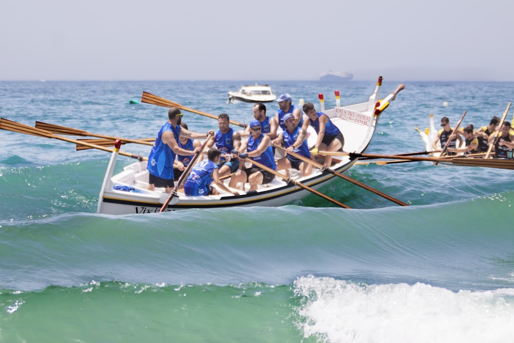 昼間は海で青と白のボートに乗る人々