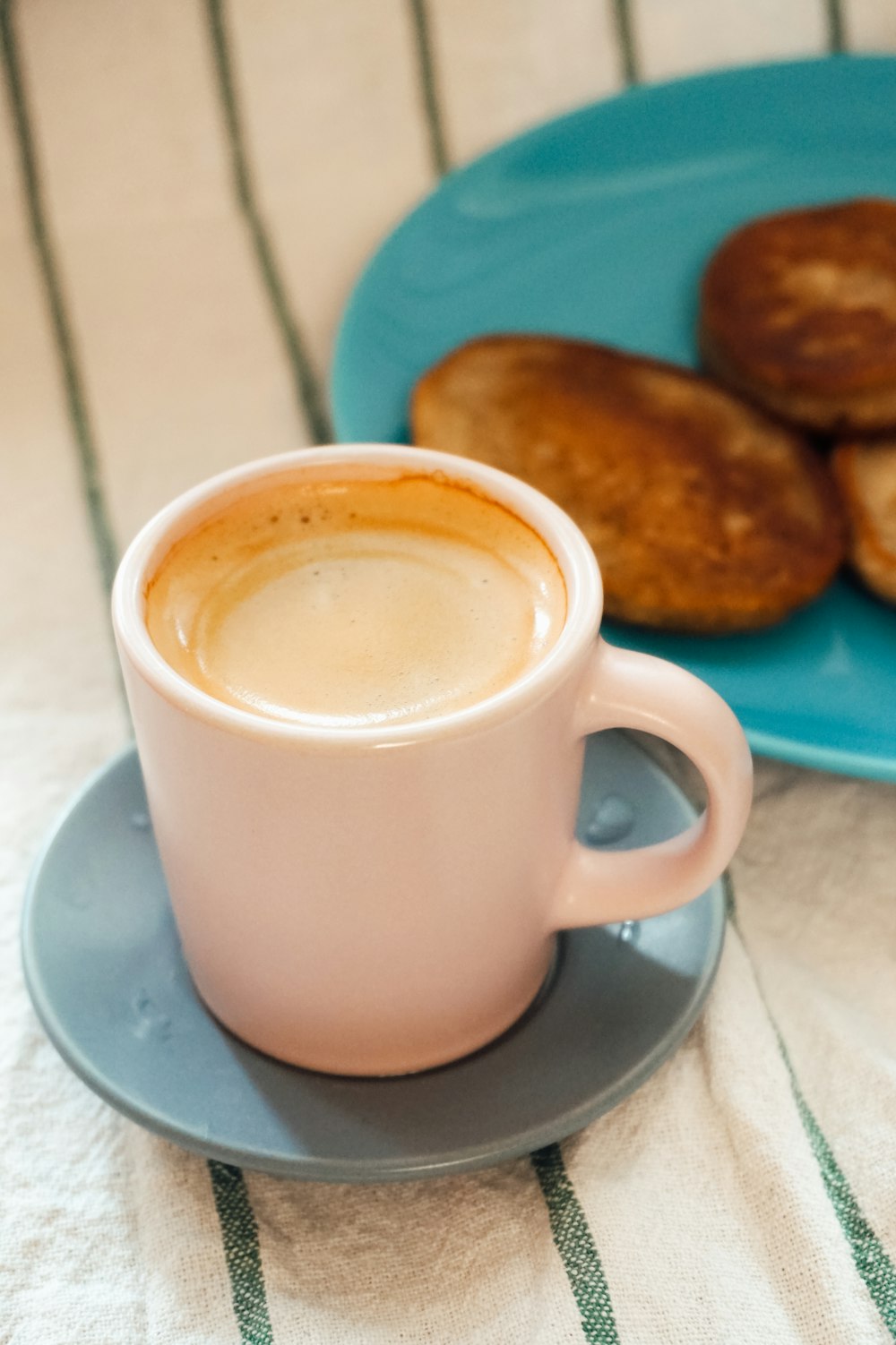 brown ceramic mug on white saucer