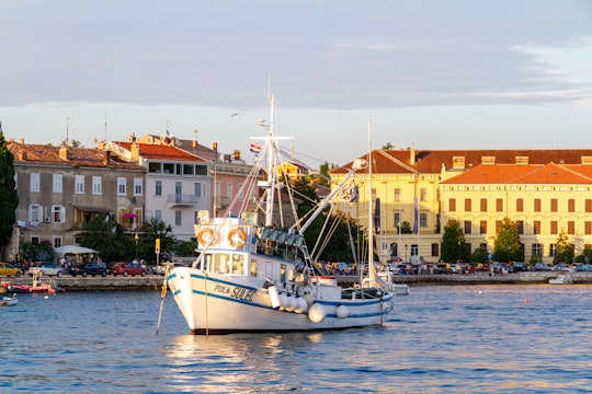 white and blue boat on dock during daytime in Rovinj Croatia