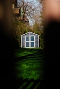 white wooden house on green grass field during sunset