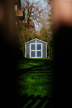 white wooden house on green grass field during sunset