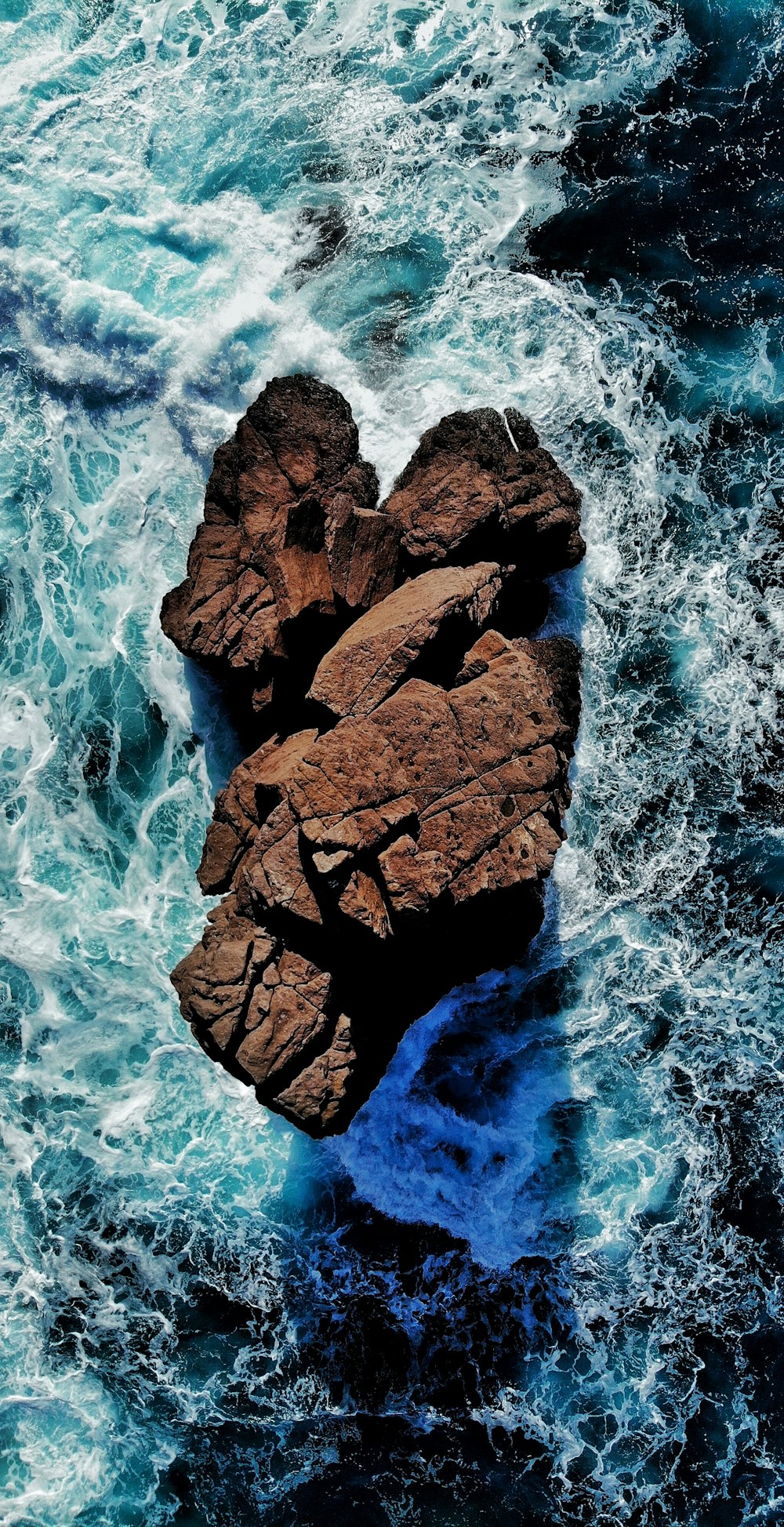 formação rochosa marrom no corpo de água