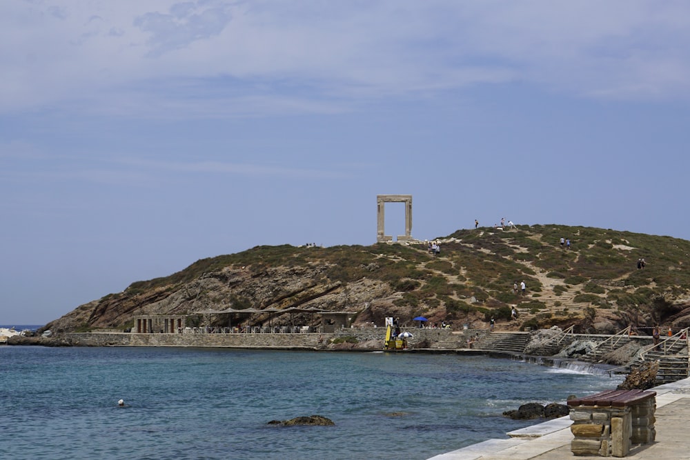 people swimming on sea near brown mountain during daytime