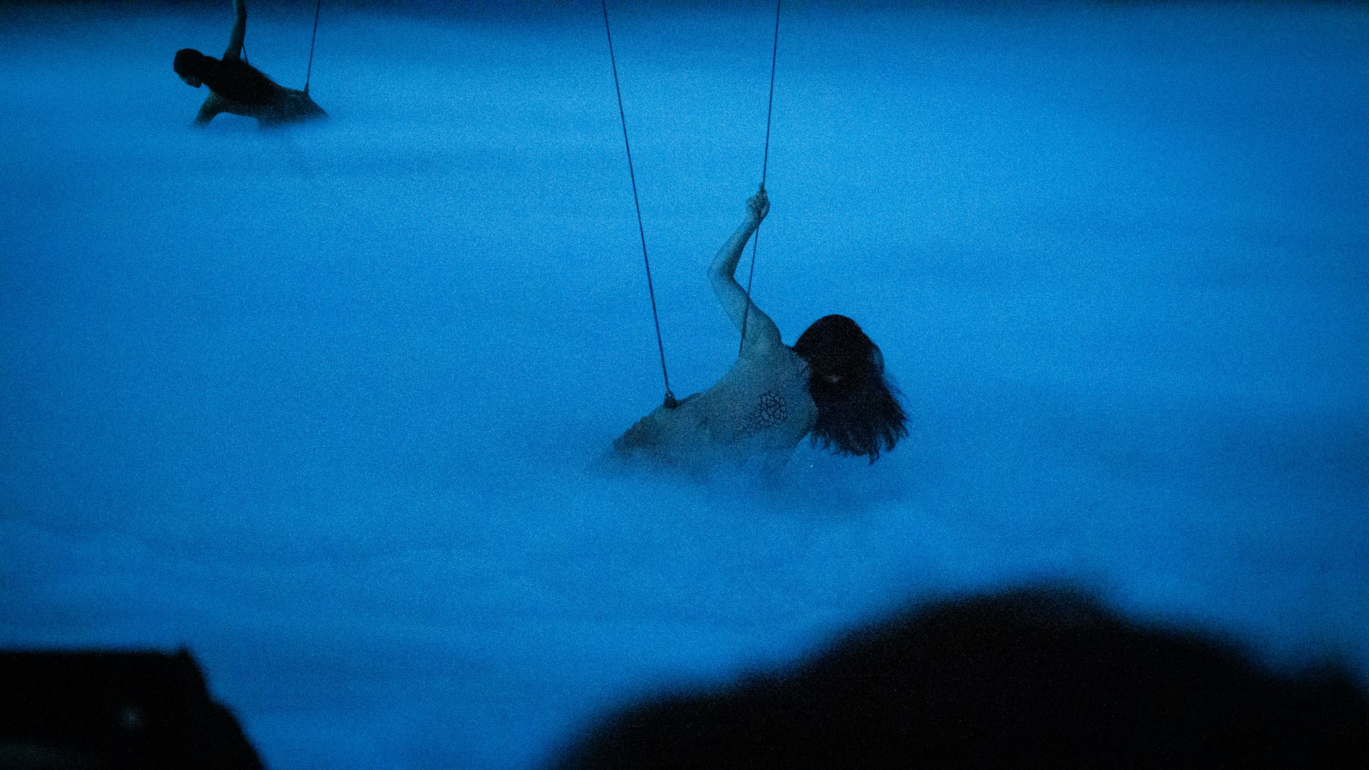person in water holding white rope
