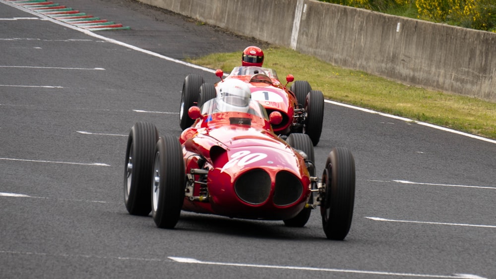 dois carros de corrida dirigindo por uma pista de corrida