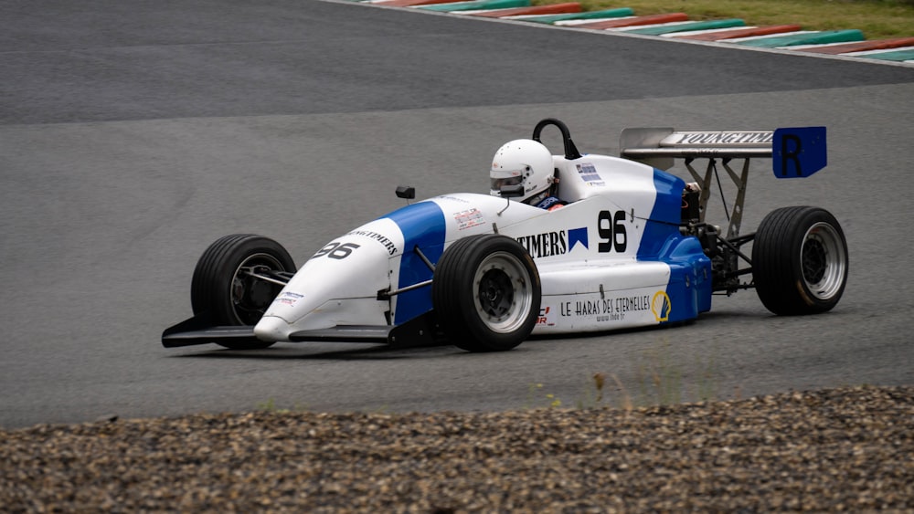 white and blue racing car on track