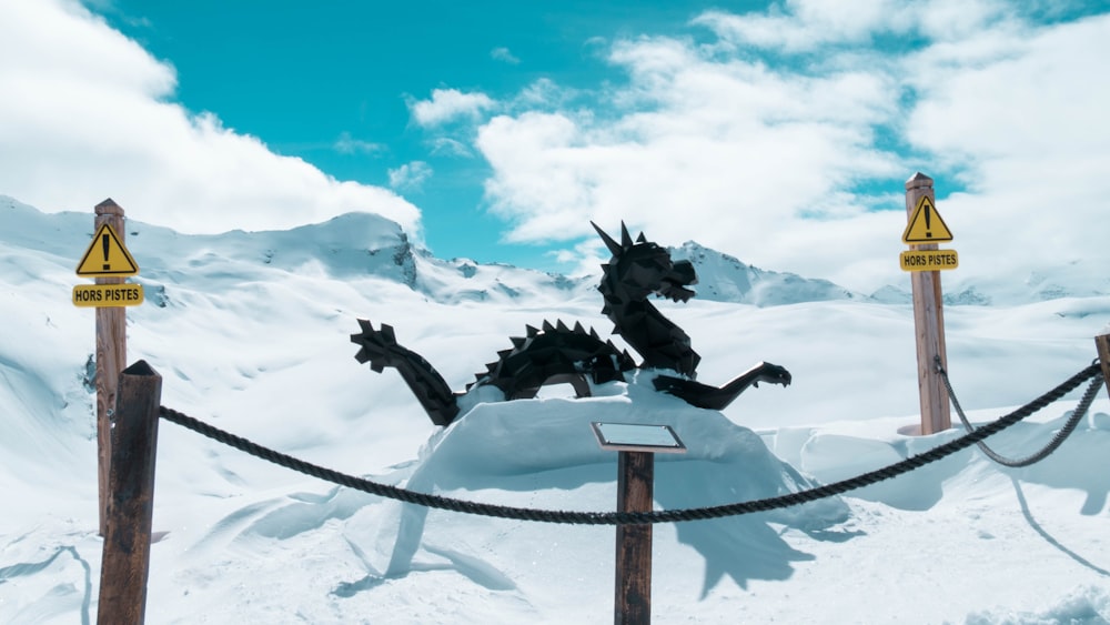 a statue of a dragon on top of a snow covered hill