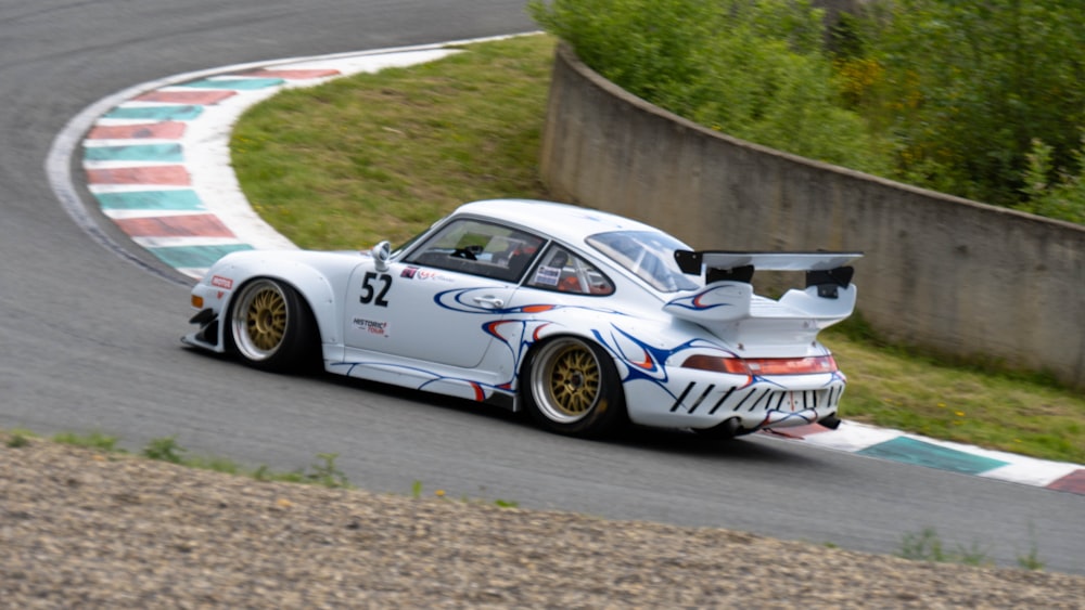 a white car driving down a race track