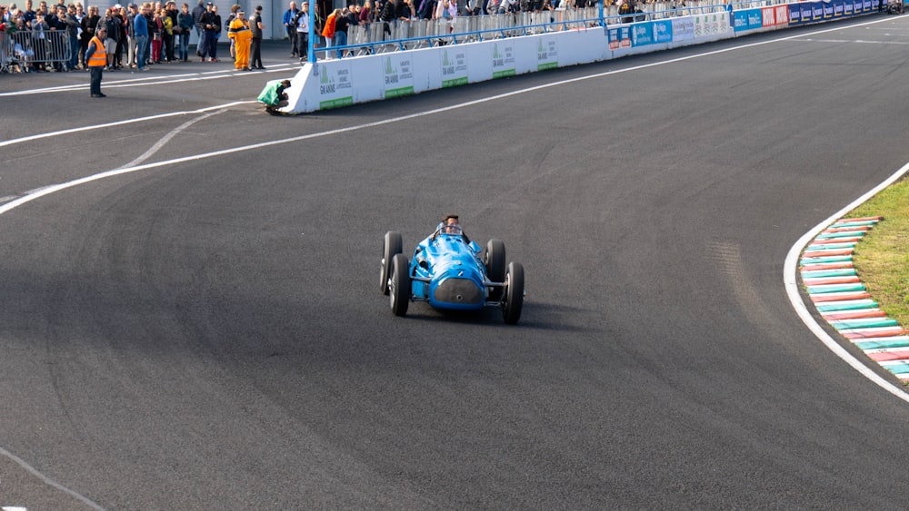 blue and black go kart on gray asphalt road during daytime