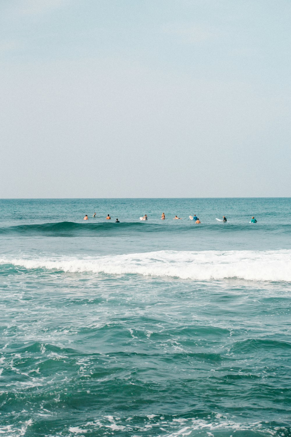 people surfing on sea waves during daytime