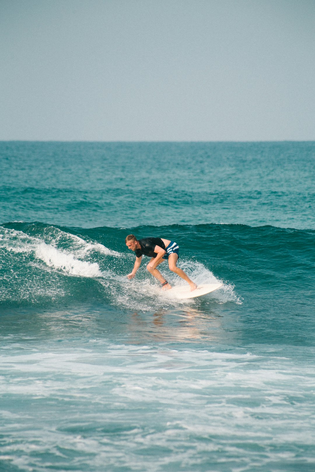 man surfing on sea waves during daytime