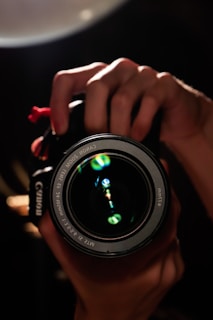 Close-up of a professional camera lens with golden light reflections.