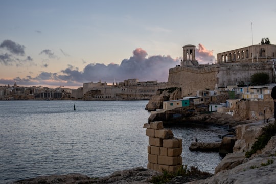 brown concrete building near body of water during daytime in St. John's Co-Cathedral Malta