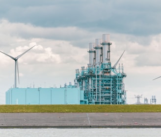 white and blue factory under white clouds during daytime