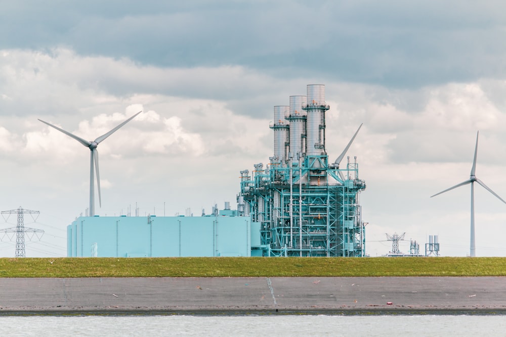 white and blue factory under white clouds during daytime