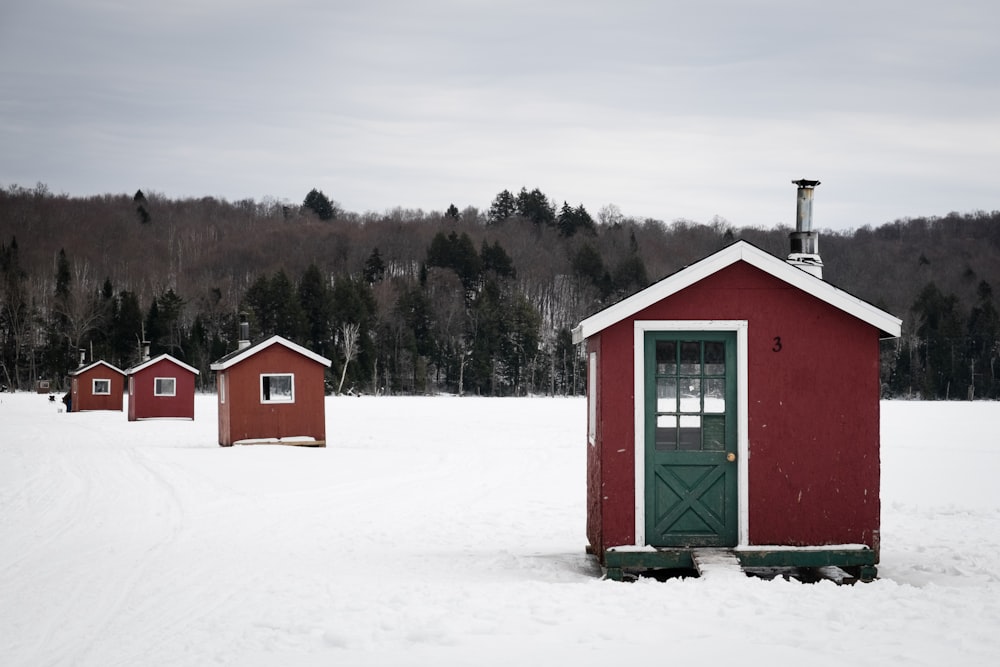 red and green wooden house on snow covered ground