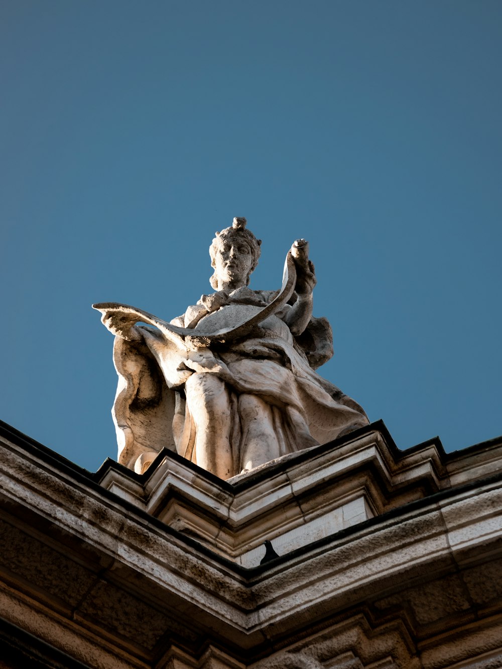 a statue of a woman sitting on top of a building