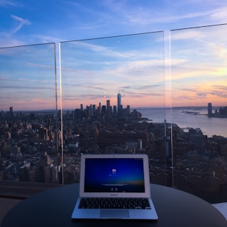A sleek laptop displaying the fanar professional networking platform with Riyadh's skyline at dusk in the background.