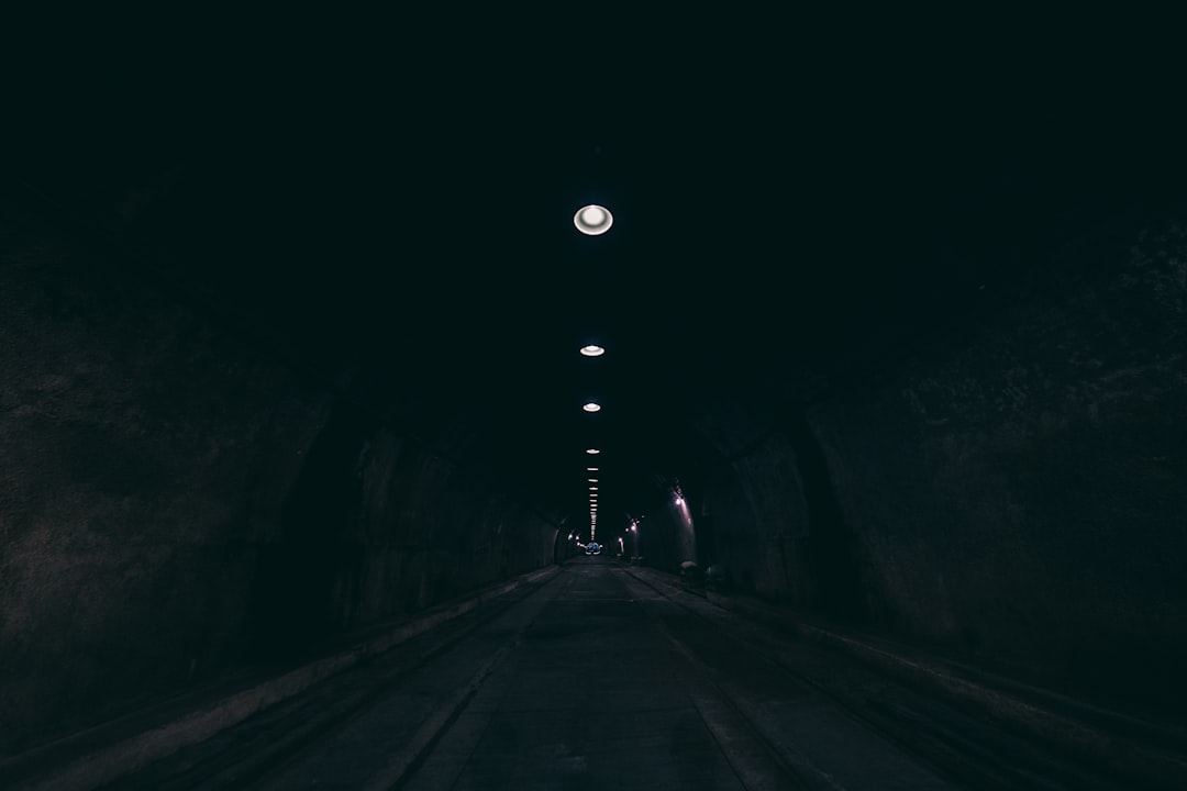 person walking on tunnel during nighttime