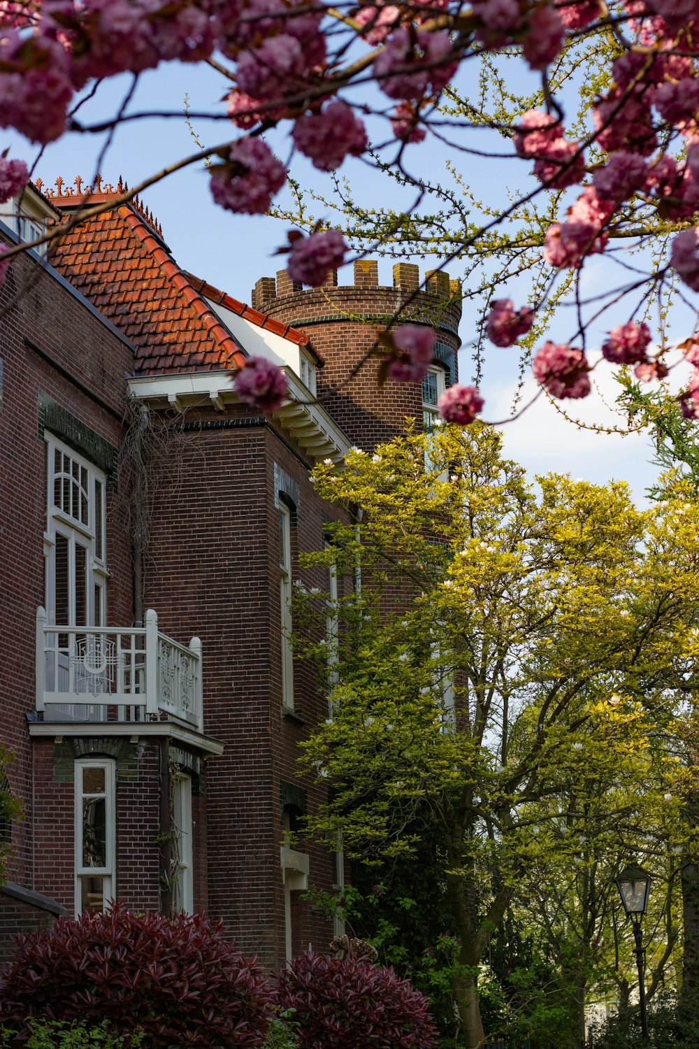 brown brick house with red and yellow flowers