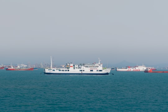 white ship on sea under white sky during daytime in Merak Sea Port Indonesia