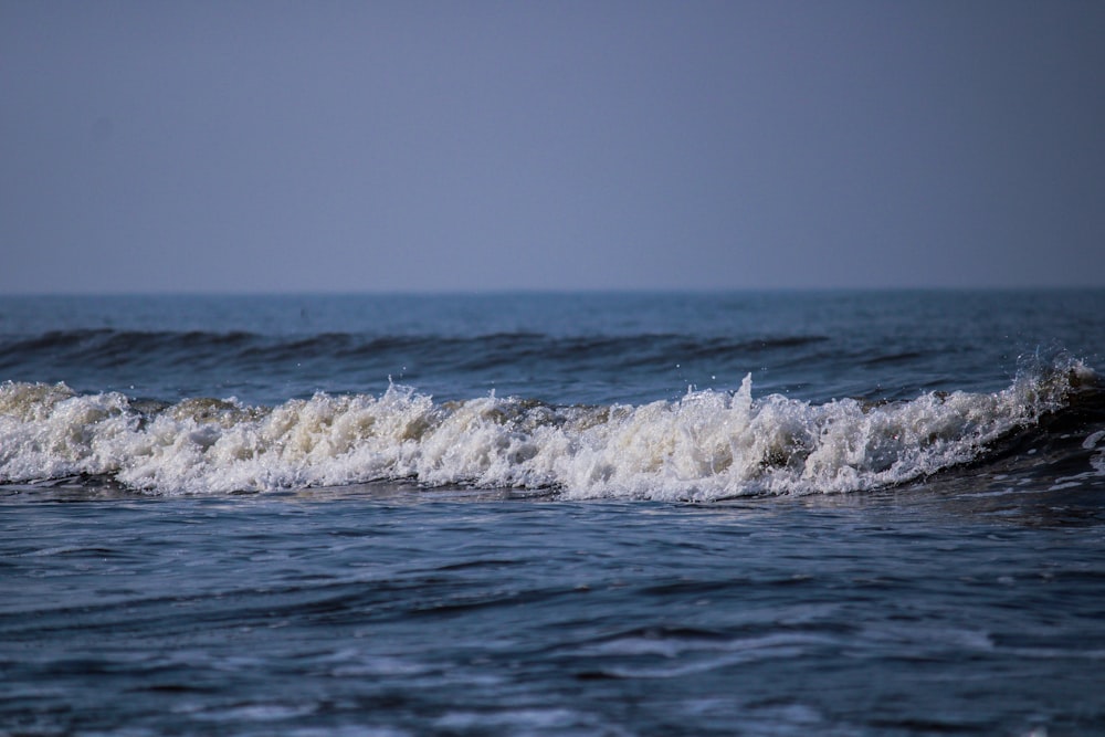 ocean waves crashing on shore during daytime