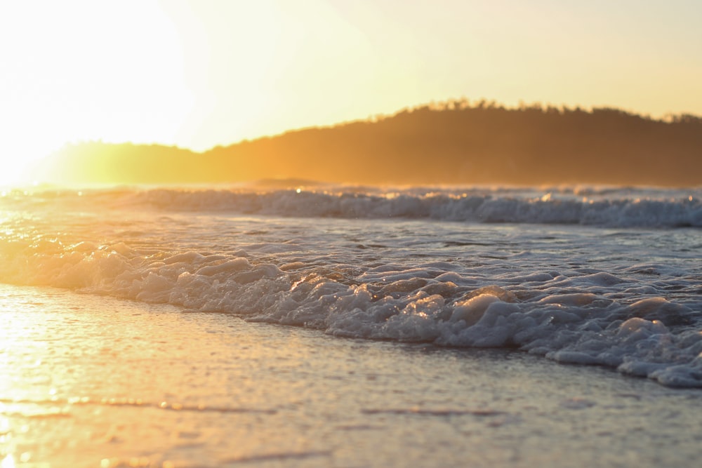 sea waves on shore during sunset