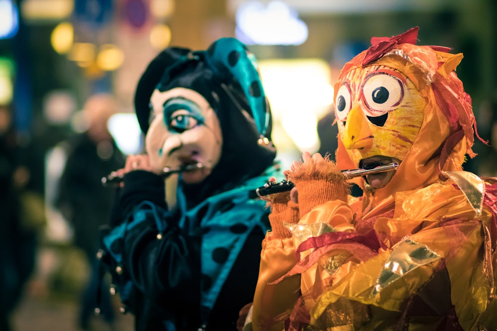 person in blue and orange mask holding orange and yellow flower