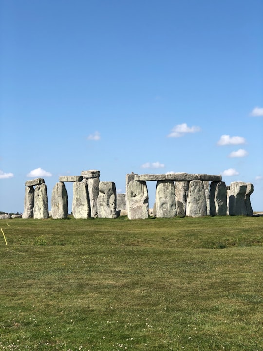 gray rock formation on green grass field under blue sky during daytime in Stonehenge United Kingdom