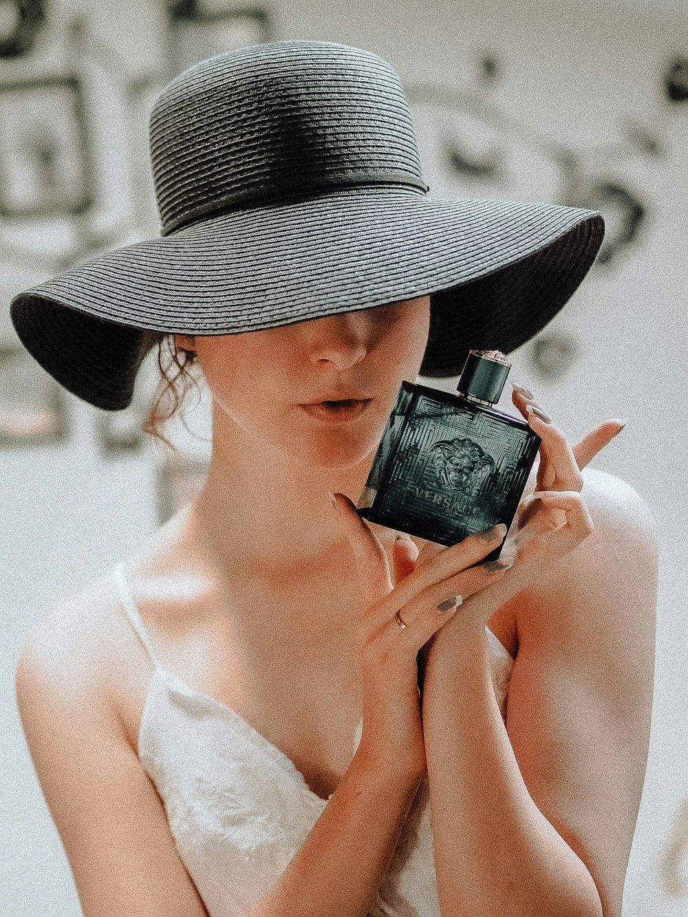 woman in white tank top holding black and silver camera