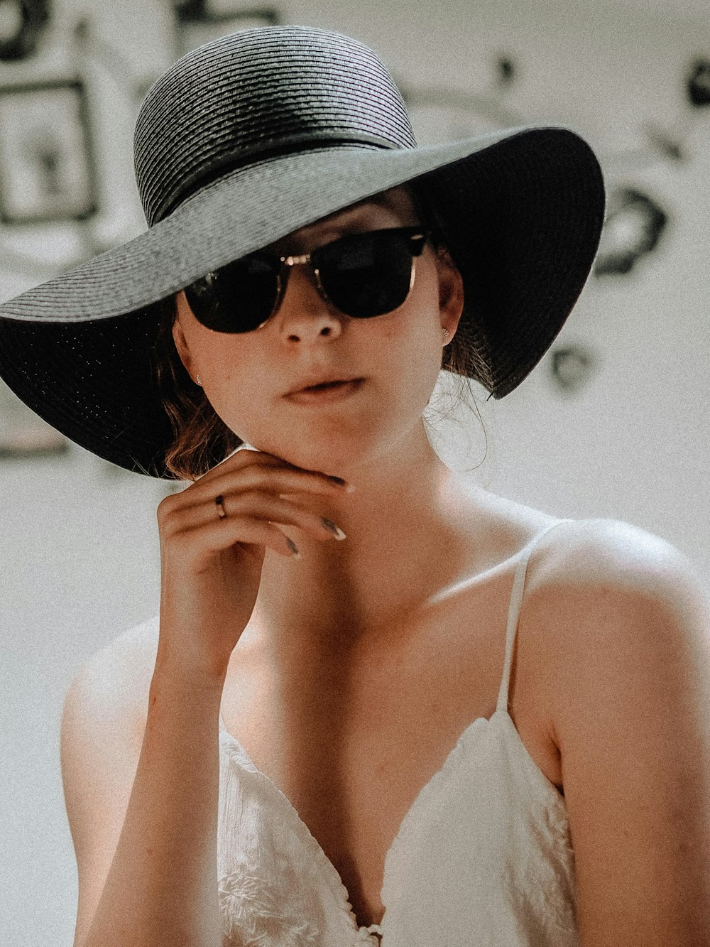 woman in white tank top wearing brown sun hat