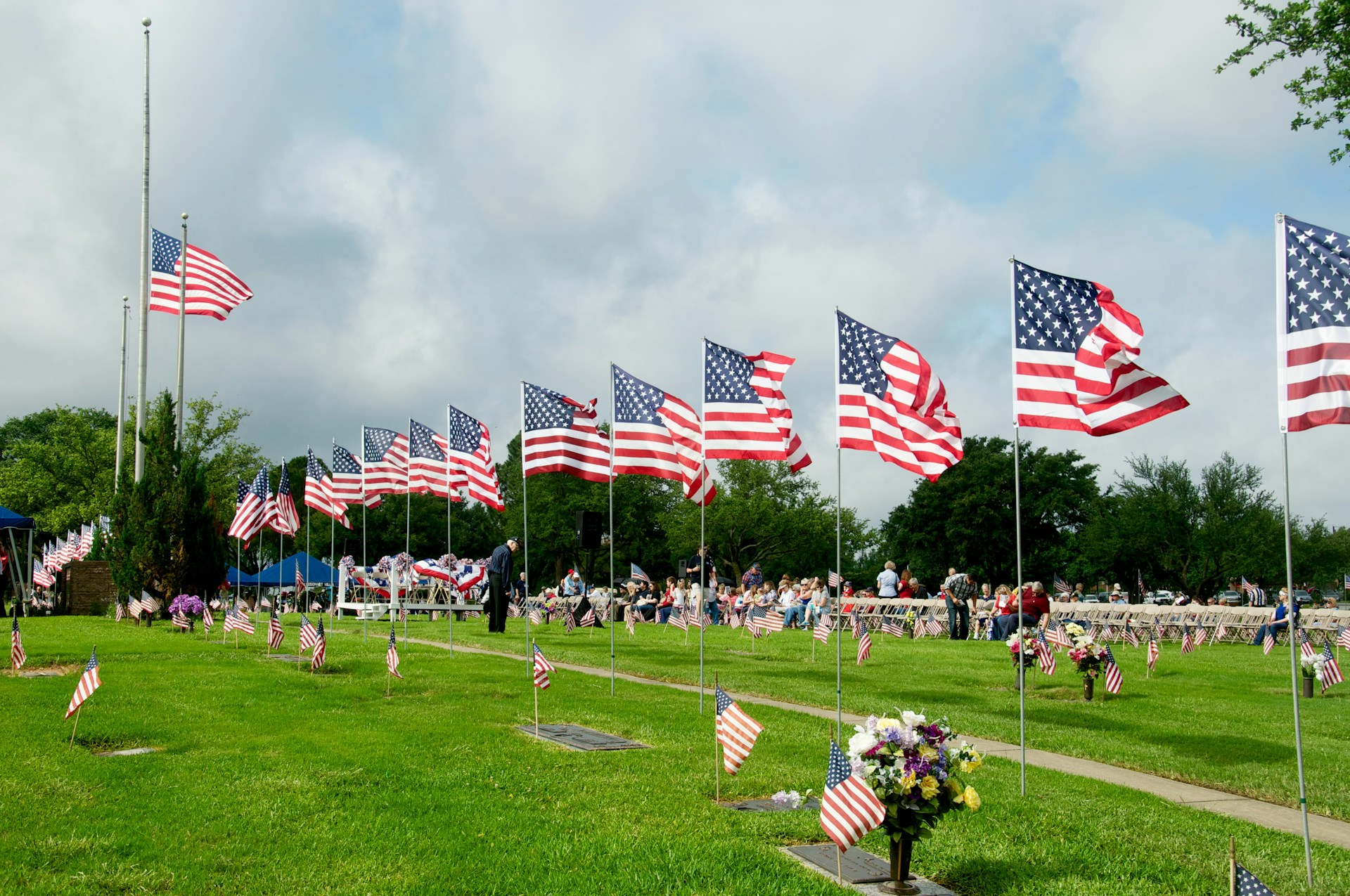 us a flags on green grass field under cloudy sky during daytime