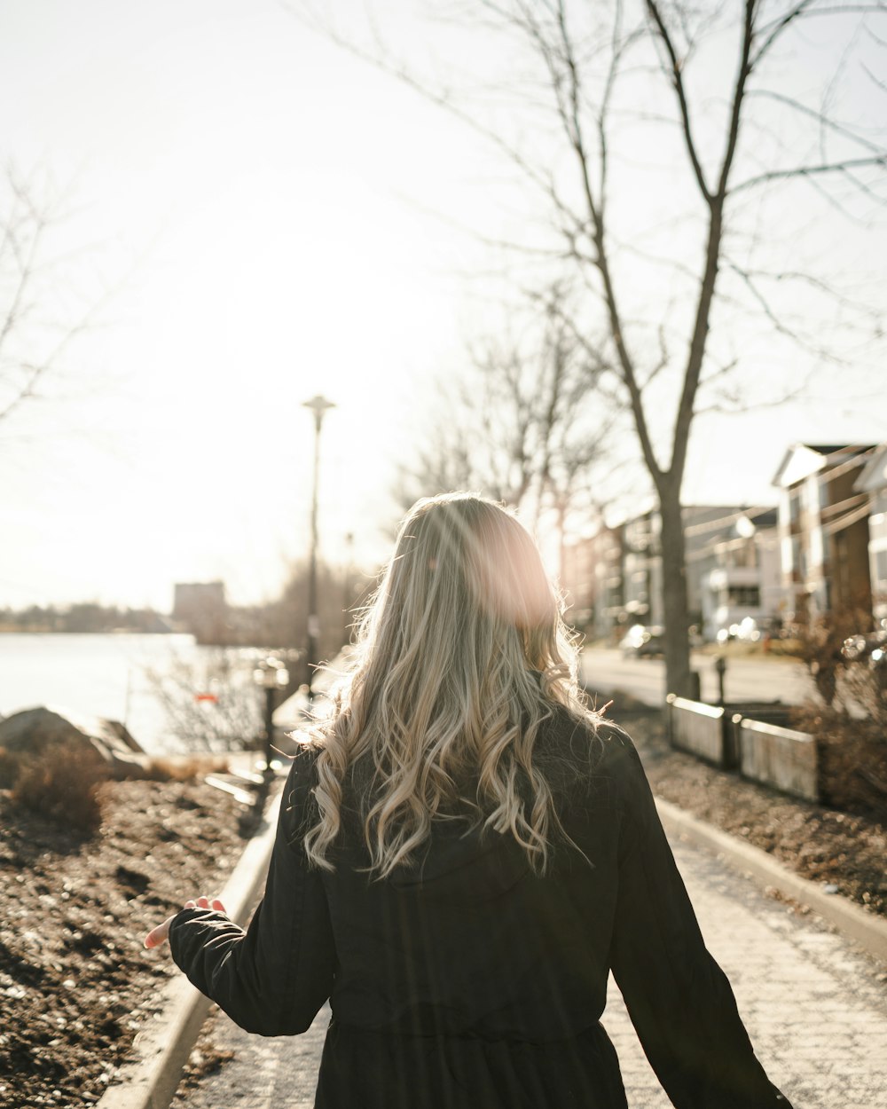 woman in black long sleeve shirt standing on brown dirt road during daytime