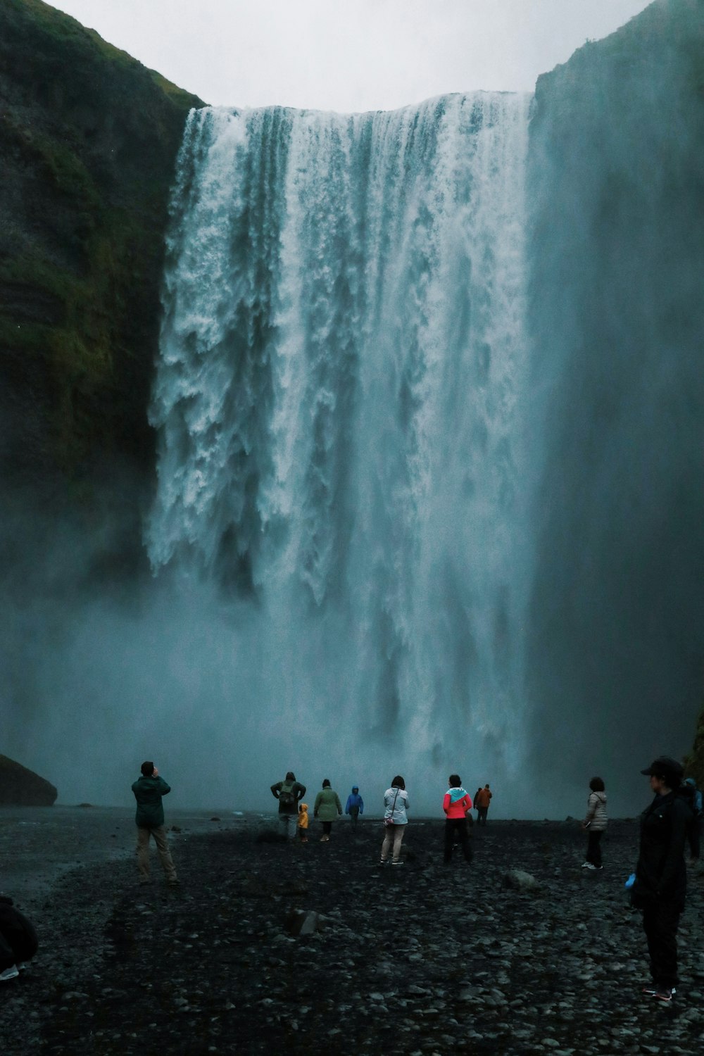 people standing near waterfalls during daytime