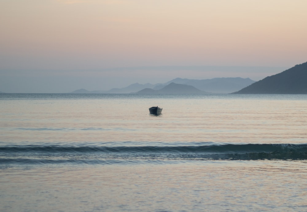 black boat on sea during daytime