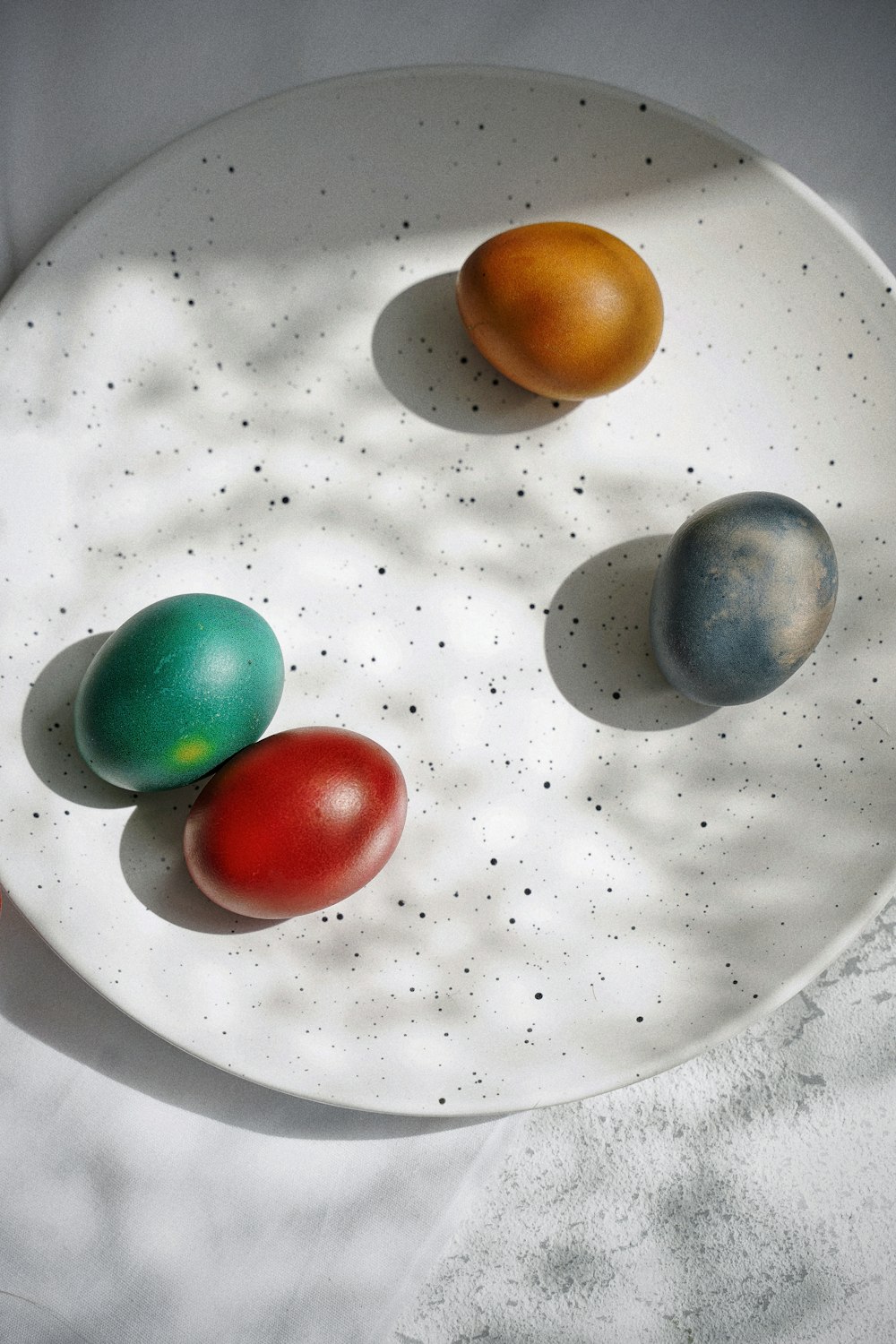 red green yellow and blue marble toys on white ceramic plate