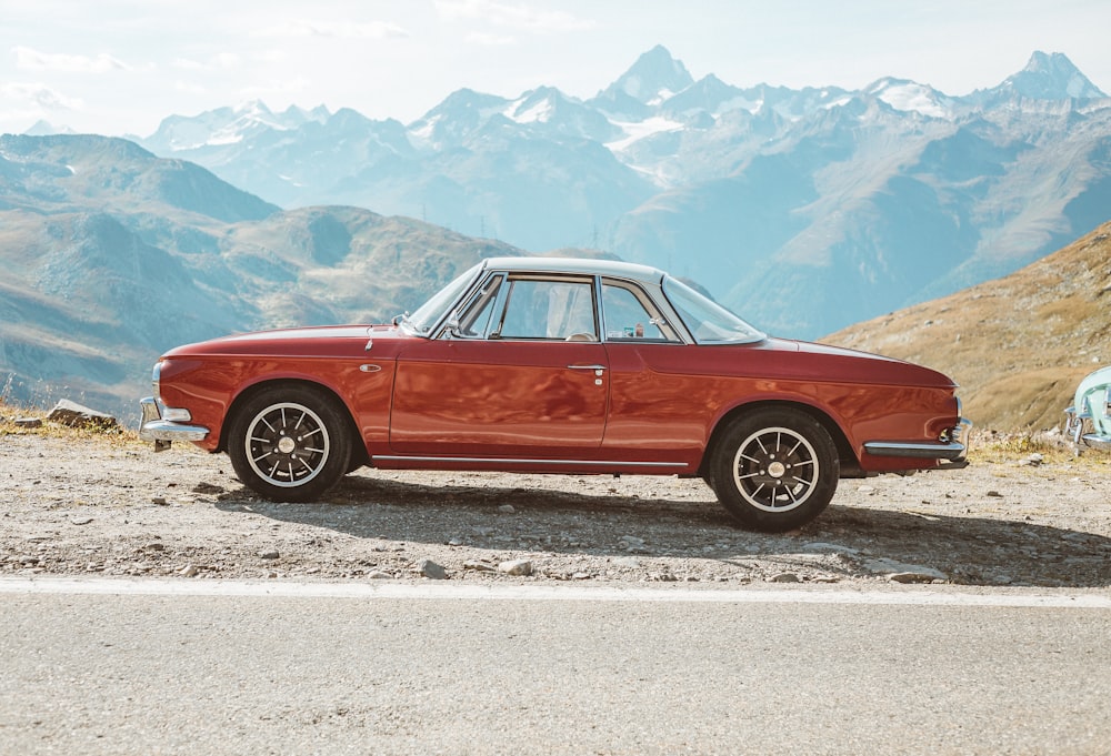 red sedan on gray sand during daytime