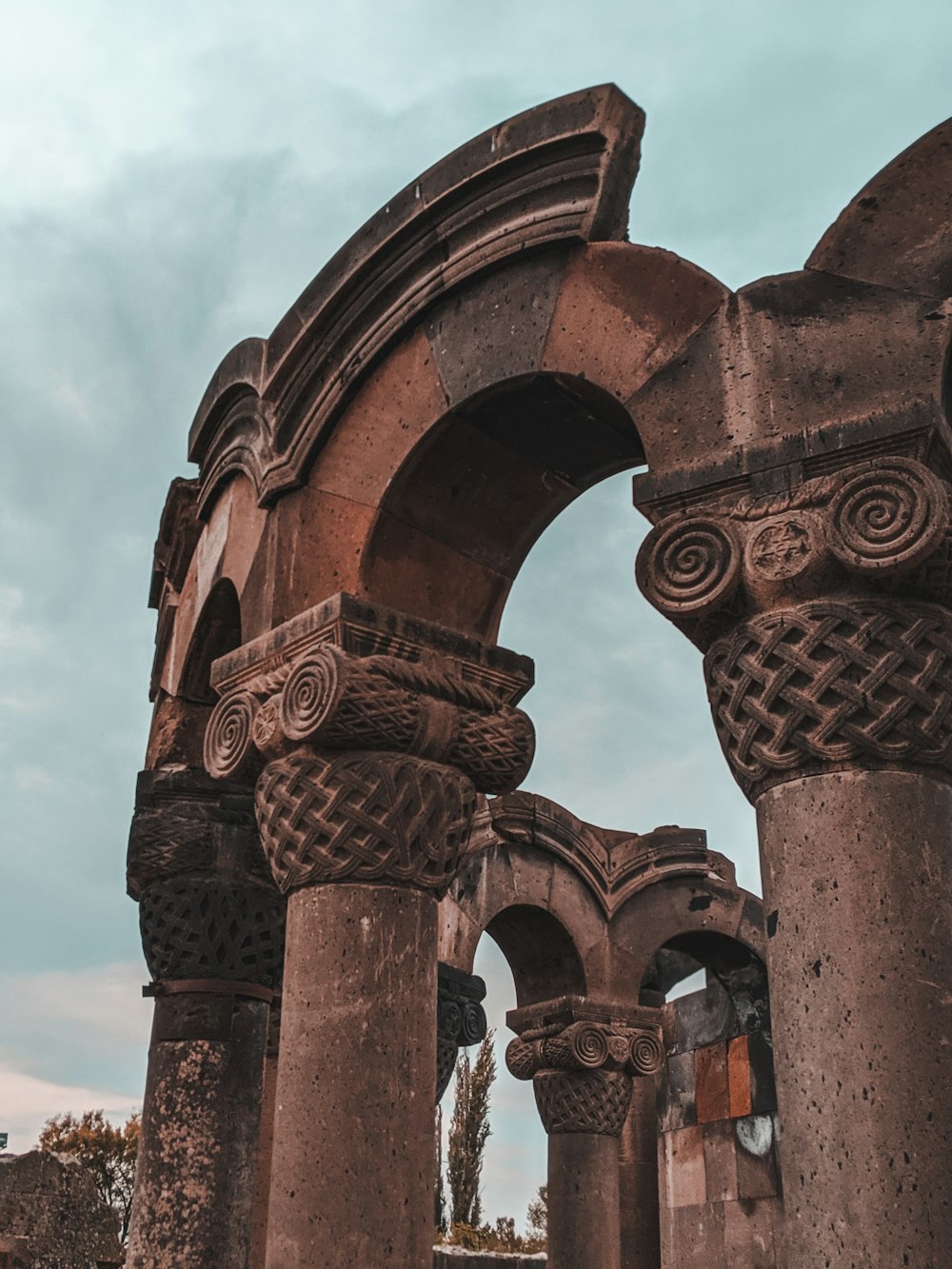 Arco di cemento marrone sotto il cielo blu durante il giorno