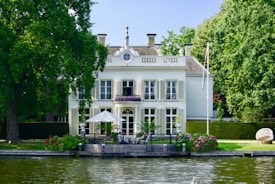 white and green concrete building near body of water during daytime