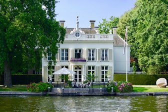 white and green concrete building near body of water during daytime