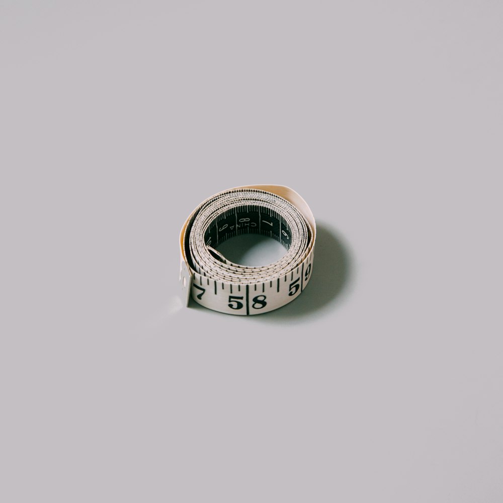 silver and gold ring on white surface