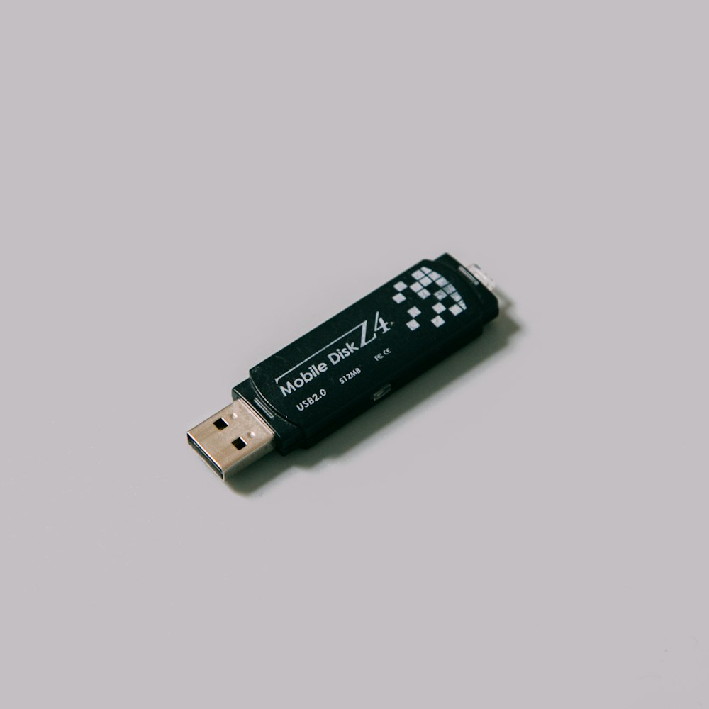 Unidad flash USB negra sobre superficie blanca