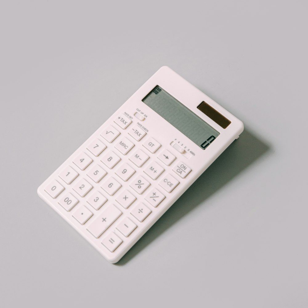 calcolatrice bianca su tavolo bianco