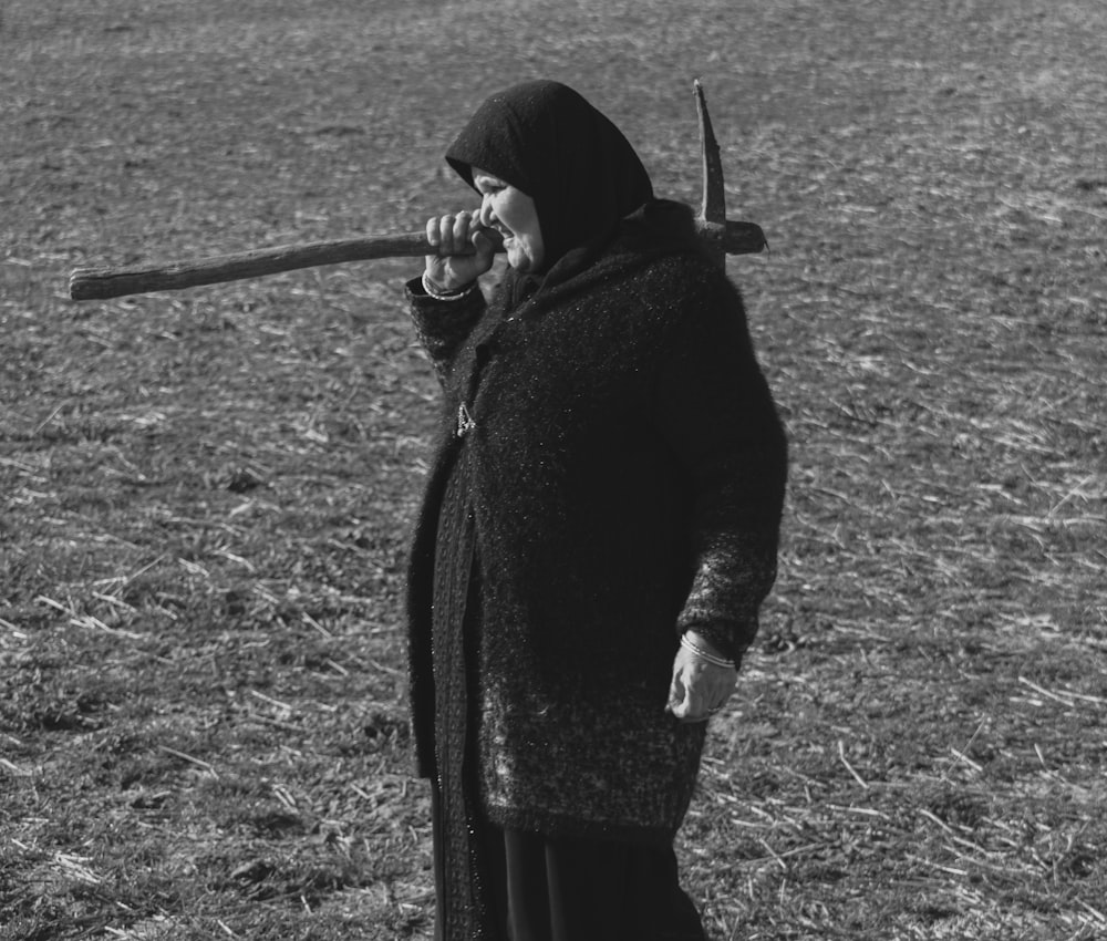 woman in black coat holding black metal rod