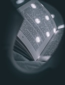 Close-up of an open e-book on a tablet, glowing softly in dim light.