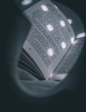 A close-up of a book cover glowing softly against a starry cosmic background.
