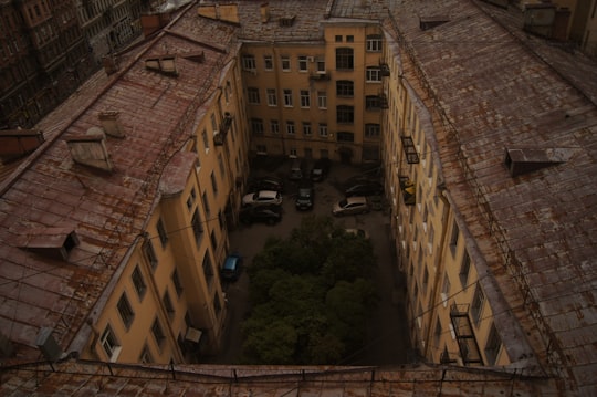 people walking on street between brown concrete buildings during daytime in Saint Petersburg Russia