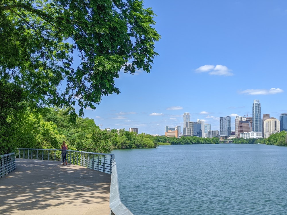 people walking on sidewalk near body of water during daytime